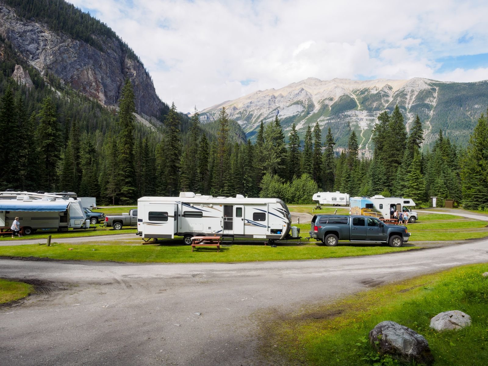 Recreational vehicles parked below snow-capped mountains