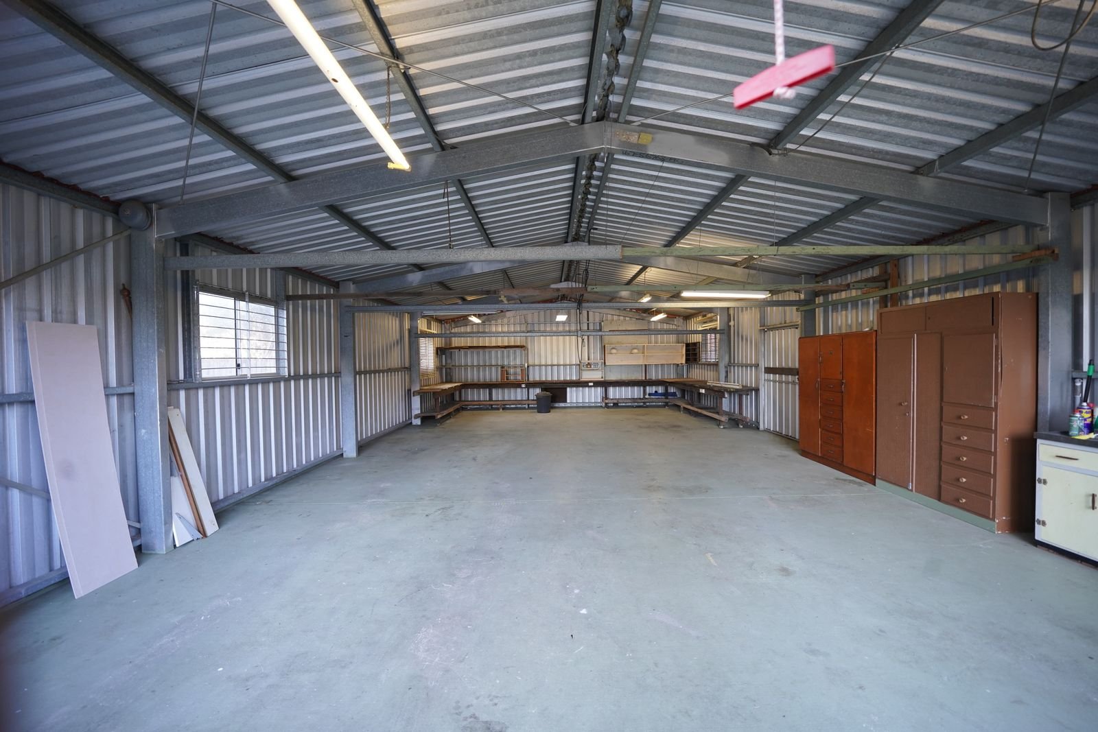 Empty shop interior with a bare concrete floor and steel ceiling