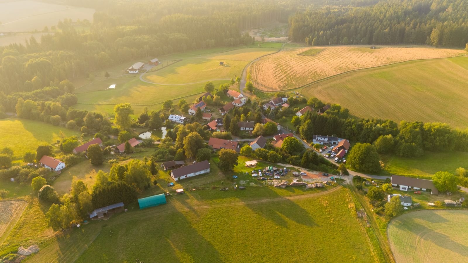 Small settlement spread across a broad green valley floor